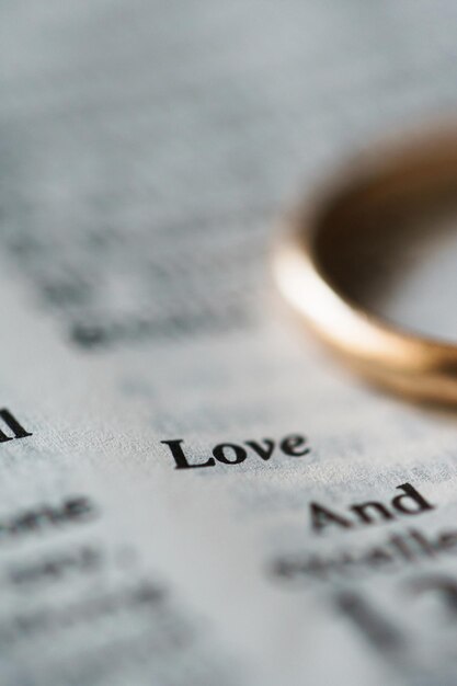 Holden wedding ring and opened pages of holy bible represents the concept of marriage and the love between two Christians