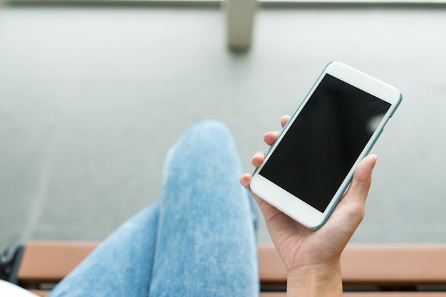 Holding cellphone and sit on the bench