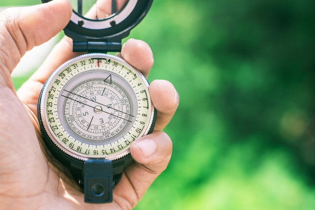 Holding compass on blurred background.