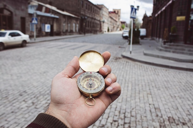 Holding a compass in the city at the crossroads