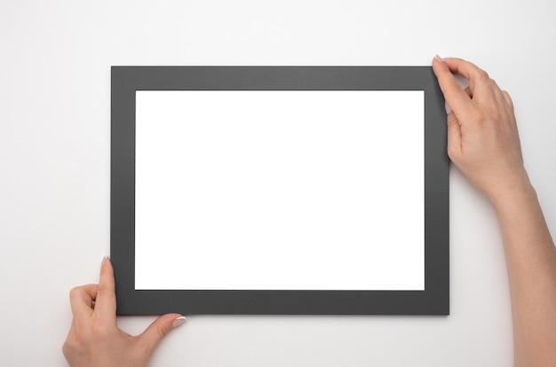 Holding frame mockup Photo Mockup Woman hands hold black frame For frames and posters design Frame size A4 blank photo frame border with copy space in hands close up