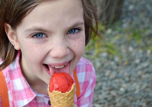 Photo holding fresh waffle cone with raspberry ice cream