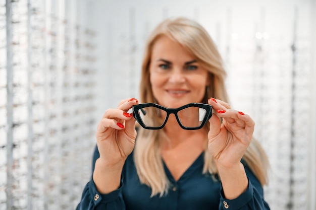 Holding glasses in hands Woman is in the store