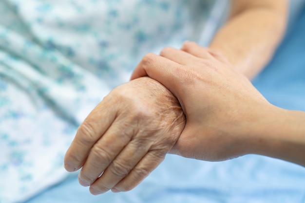 Holding hand Asian senior  woman patient with love.