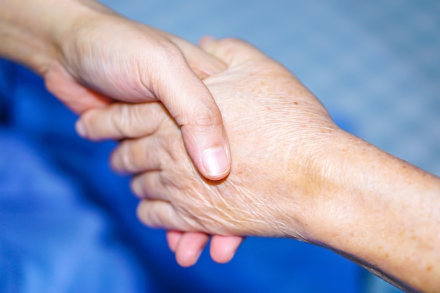 Holding hand Aziatische senior of oudere oude dame patiënt met liefde