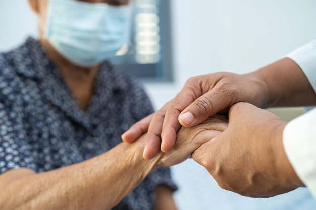 Holding hands Asian senior or elderly old lady woman patient with love care encourage and empathy at nursing hospital ward healthy strong medical concept