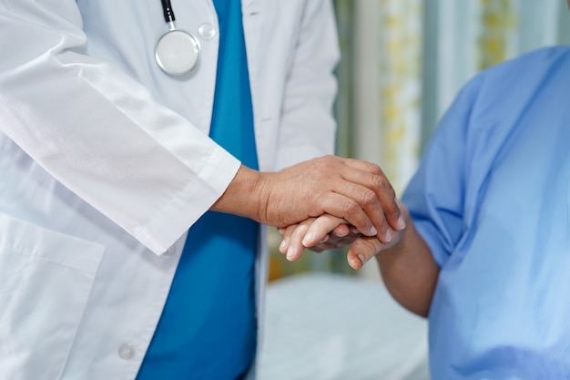 Holding hands Asian senior woman patient with love and care.