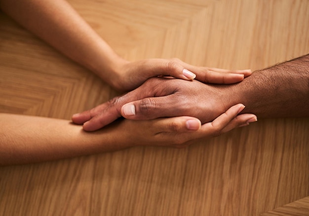 Holding hands in love and support showing care comfort and consoling a friend Two people together in unity solidarity and trust showing hope faith and kindness while helping and bonding closeup