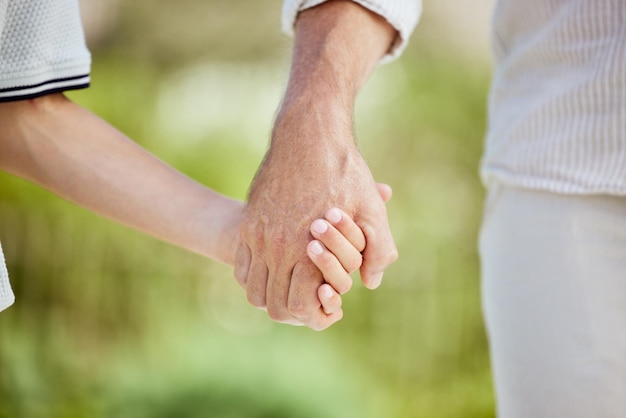 Holding hands outdoor and walking in nature family and bonding of parent with child calm and support Garden care and trust of kid with dad person and youth in park love or affection in weekend