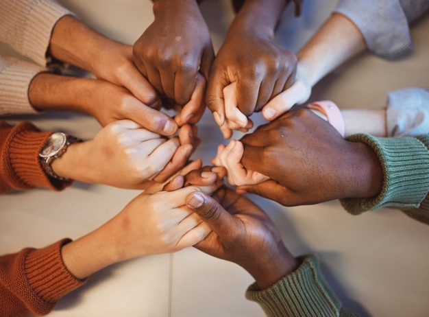 Holding hands top view and group prayer of people with hope support or faith religion or spiritual praise Community teamwork and Christian friends men and women praying together to worship God