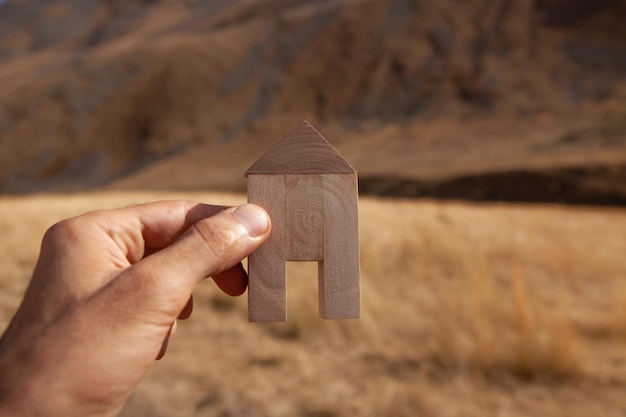 Holding a house in his hand on the background of nature