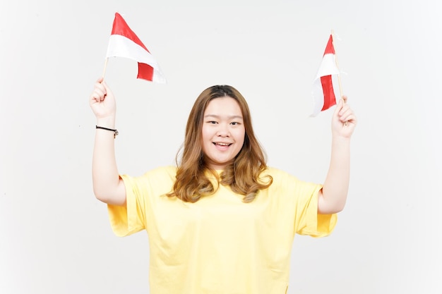 黄色のTシャツを着ている美しいアジアの女性のインドネシアのインドネシアの旗の独立を保持します。