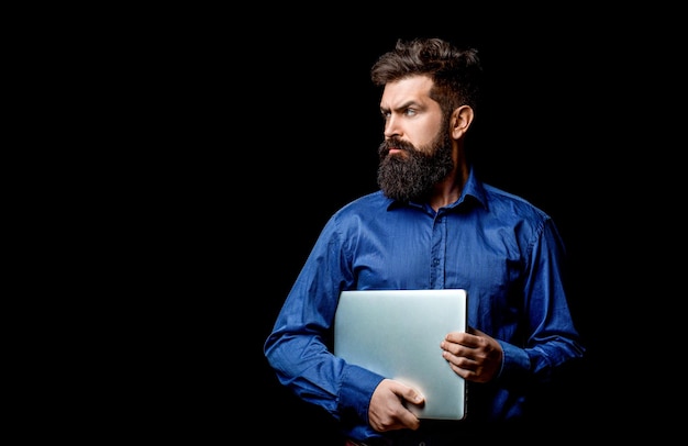 Holding laptop computer Serious handsome bearded man worker laptop Bearded male