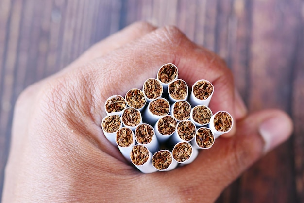 Holding many cigarettes on table close up