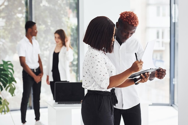 Holding notepad Group of african american business people working in office together