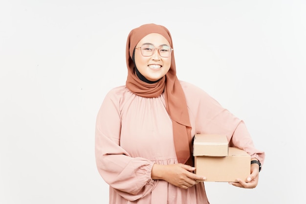 Holding package box or cardboard box of beautiful asian woman\
wearing hijab isolated on white