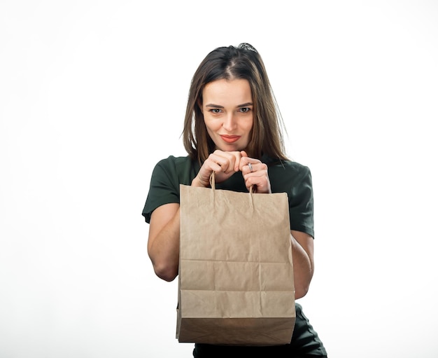 Holding a paper bag with delicate care a woman is holding a brown paper bag