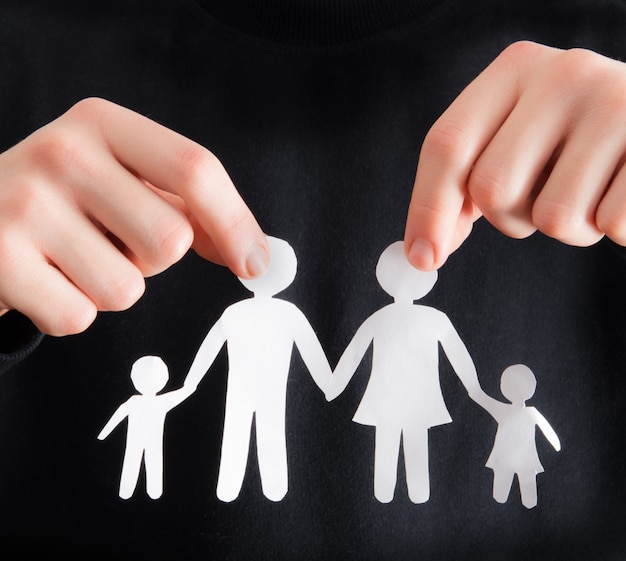 holding a paper cutout in the form of a family