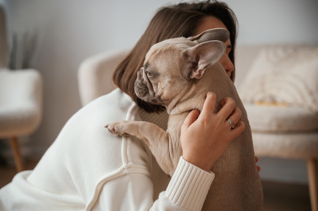 Photo holding pet in hands care and love young woman is with her pug dog at home
