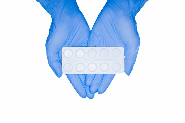 Holding pil capsule drugs in de hand latex handschoen witte achtergrond. geneeskunde voor verschillende ziekten ziekenhuisconcept.