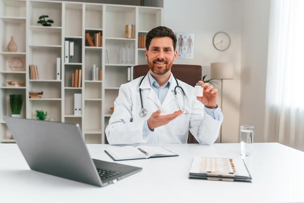 Holding pills Doctor in formal clothes is working in the cabinet
