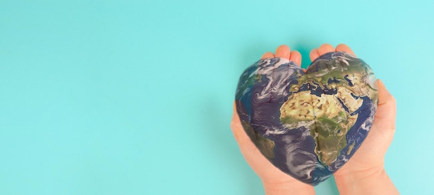 Photo holding planet earth in heart shape forest and ocean environment concept connect and protect nature