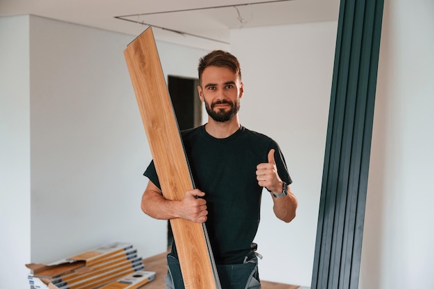 Holding the planks Man is installing new laminated wooden floor