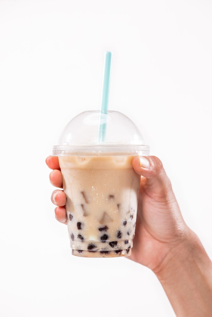 Photo holding a plastic glass of refreshing taiwan iced milk tea with bubble (boba)