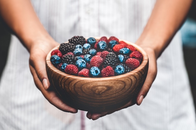 Holding a plate full of berries.