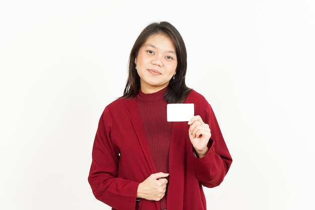 Tenendo e mostrando la carta di credito in bianco di bella donna asiatica che indossa maglietta rossa isolata su white