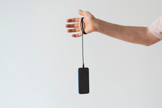 Holding smarphone hanging on the cable power charge