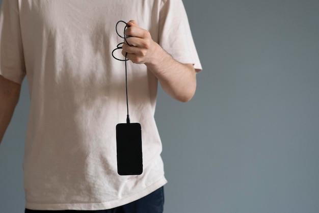 Holding smarphone hanging on the cable power charge