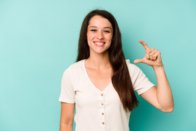 holding something little with forefingers smiling and confident