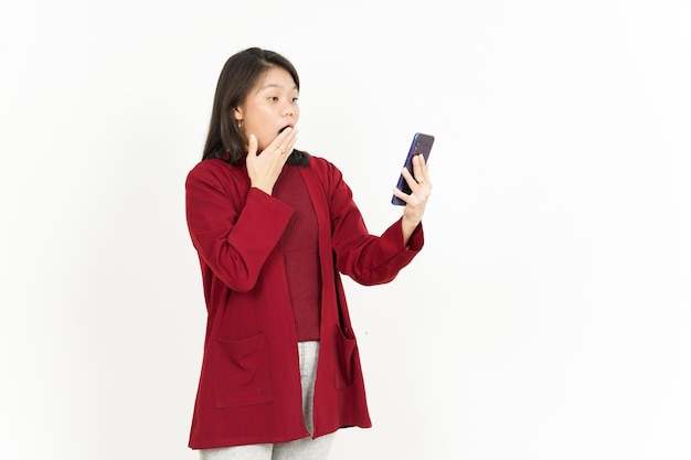 흰색 배경에 고립 된 빨간 셔츠를 입고 아름 다운 아시아 여자의 스마트 폰을 들고 사용