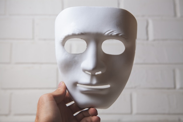 Holding a white anonymous mask
