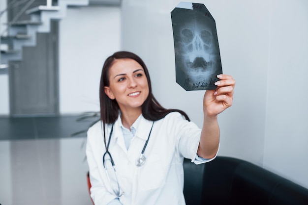 Holding xray Young nurse indoors in modern clinic Conception of healthcare