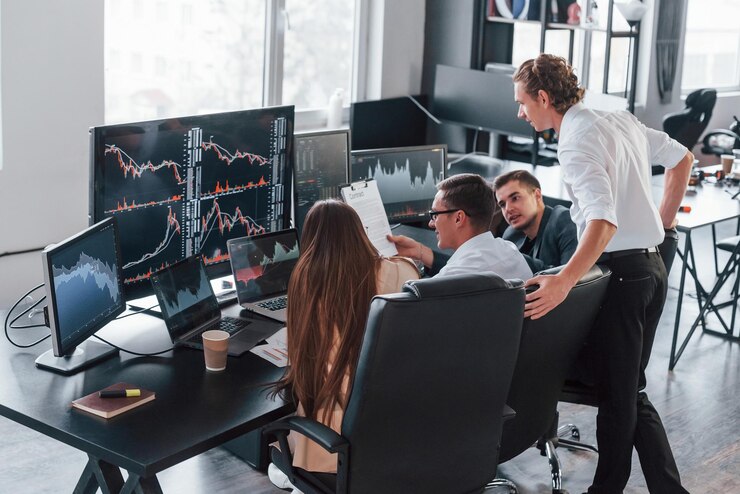 Photo holds document in hands team of stockbrokers works in modern office with many display screens