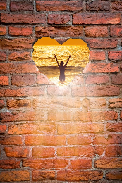 Foto buco nel muro di mattoni a forma di cuore