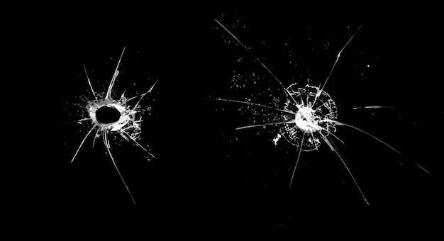 Hole in the glass with cracks isolated on a black background