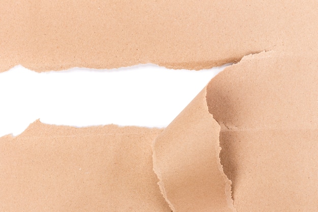 Hole ripped in brown paper on white background.