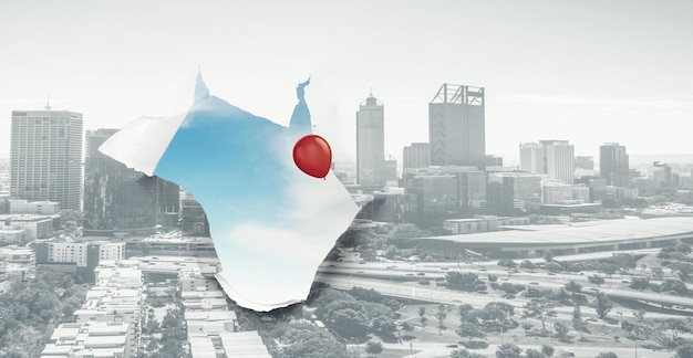 A hole in a sheet of paper with cityscape view and a red balloon