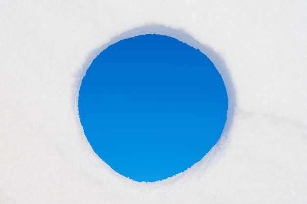 Foto buco nella neve vista del cielo blu in inverno