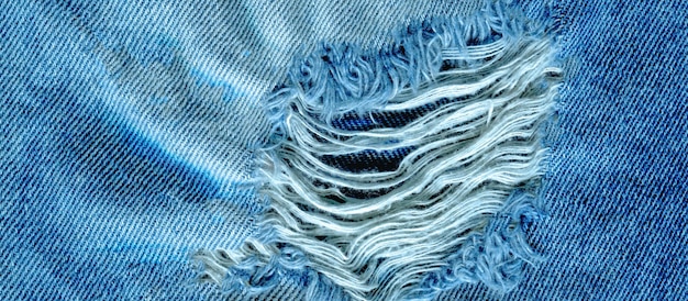 Hole and threads on denim jeans