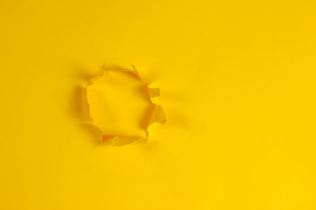 Hole of torn yellow paper. Copy space