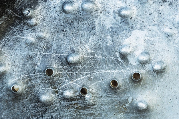 Holes from buckshot on metal surface