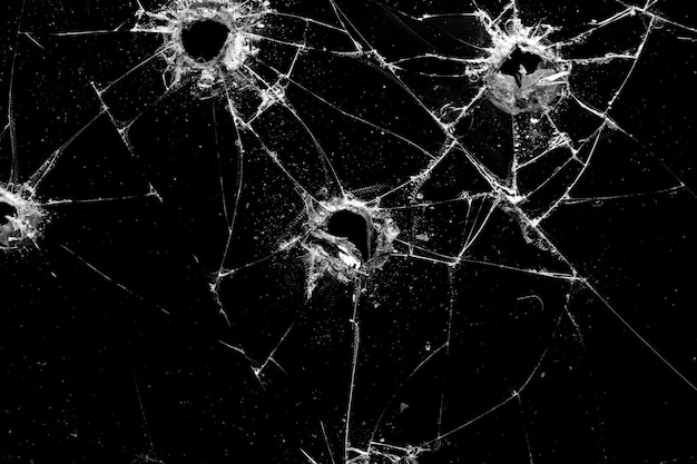 Photo holes in the glass with cracks isolated on a black background
