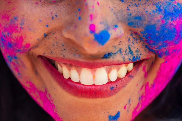 Holi Festival Of Colours Portrait of happy indian girl in holi colorcropped lips smile