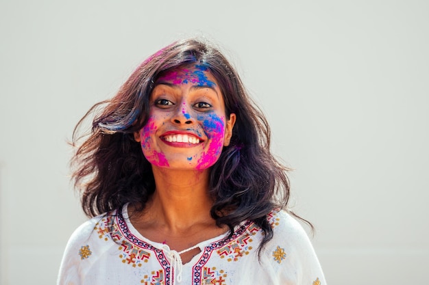 Holi Festival Of Colors Portret van een gelukkig Indisch meisje in holi-kleur dat ze danst en plezier heeft op de achtergrond van de witte muurstudio