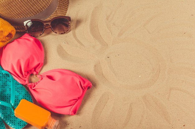 Holiday accessories on sand beach background