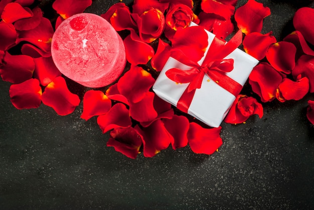 Holiday  background, Valentine's day. Bouquet of red roses, tie with a red ribbon, with wrapped gift box and red candle